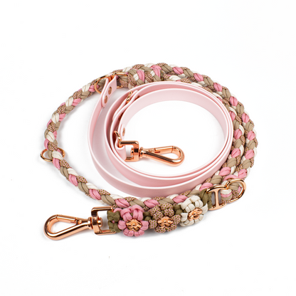 Hundeleine von Tierluxe in rosa und beige Tönen, geflochten aus Biothane und Paracord, mit Blumenverzierungen und roségoldenen Metallteilen. Die Leine kombiniert robuste Materialien mit eleganten Details für einen stilvollen und praktischen Einsatz.