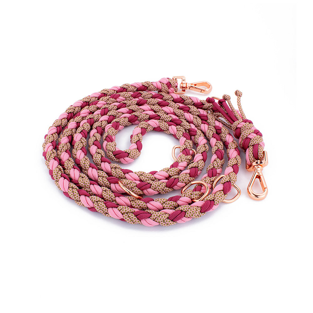 2,5m Hundeleine von Tierlux, Modell Foxy, geflochten aus drei verschiedenen Farben Paracord. Die Leine hat drei metallene D-Ringe und zwei Schnallen in roségoldener Farbe, mit denen sie dreistufig eingestellt werden kann. Es wurde von oben auf weißem Hintergrund fotografiert.